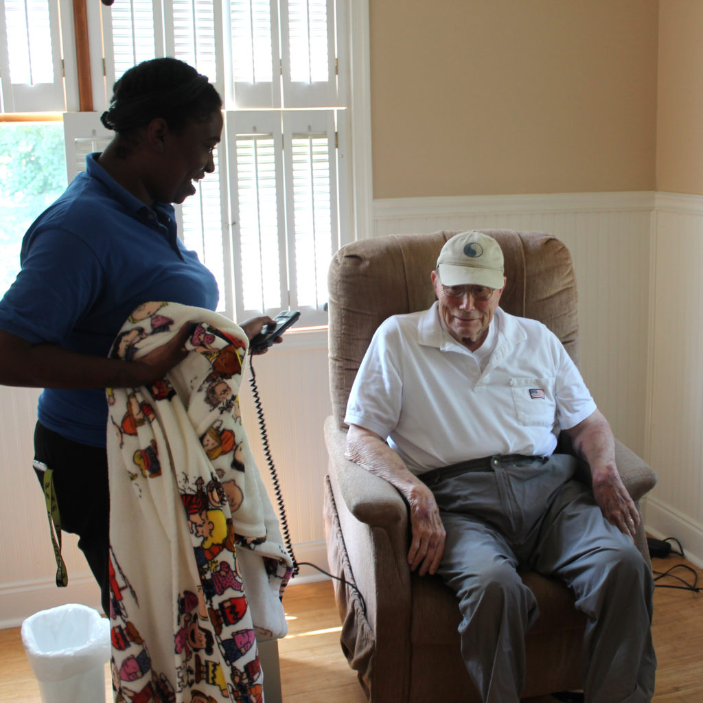 Staff Member talking to a resident while supplying a blanket.